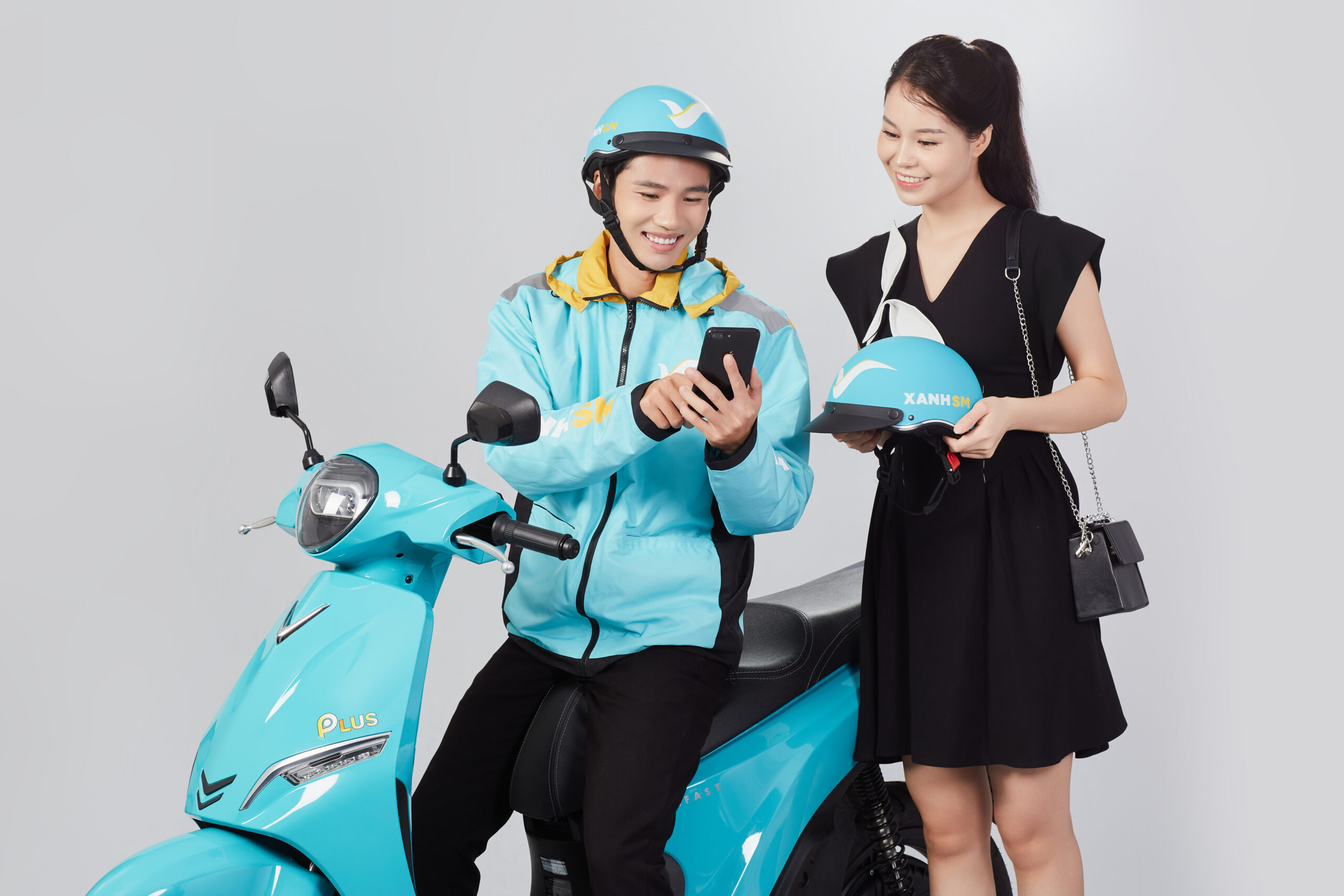 Tài xế Xanh SM Bike hỗ trợ khách hàng nhận mũ bảo hiểm trước chuyến đi