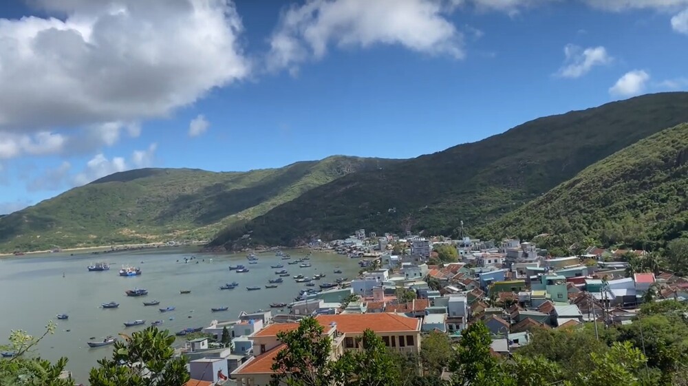 Toàn cảnh làng chài Hải Minh với những ngôi nhà nhỏ xinh nằm nép mình bên bờ biển, những con thuyền neo đậu trên cát trắng, phía xa là núi non hùng vĩ (Ảnh: Sưu tầm Internet)