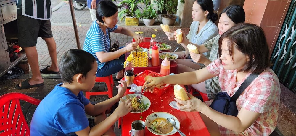 Quán bánh mì chấm Cô Hạnh với không gian vỉa hè bình dân, đông đúc thực khách (Ảnh: Sưu tầm internet)