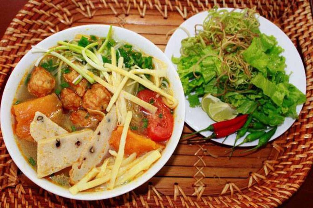 Tô bánh canh chả cá ngon lành, hấp dẫn, với nước dùng trong veo, chả cá thơm phức, ăn kèm rau sống xanh mướt (Ảnh: Sưu tầm internet)