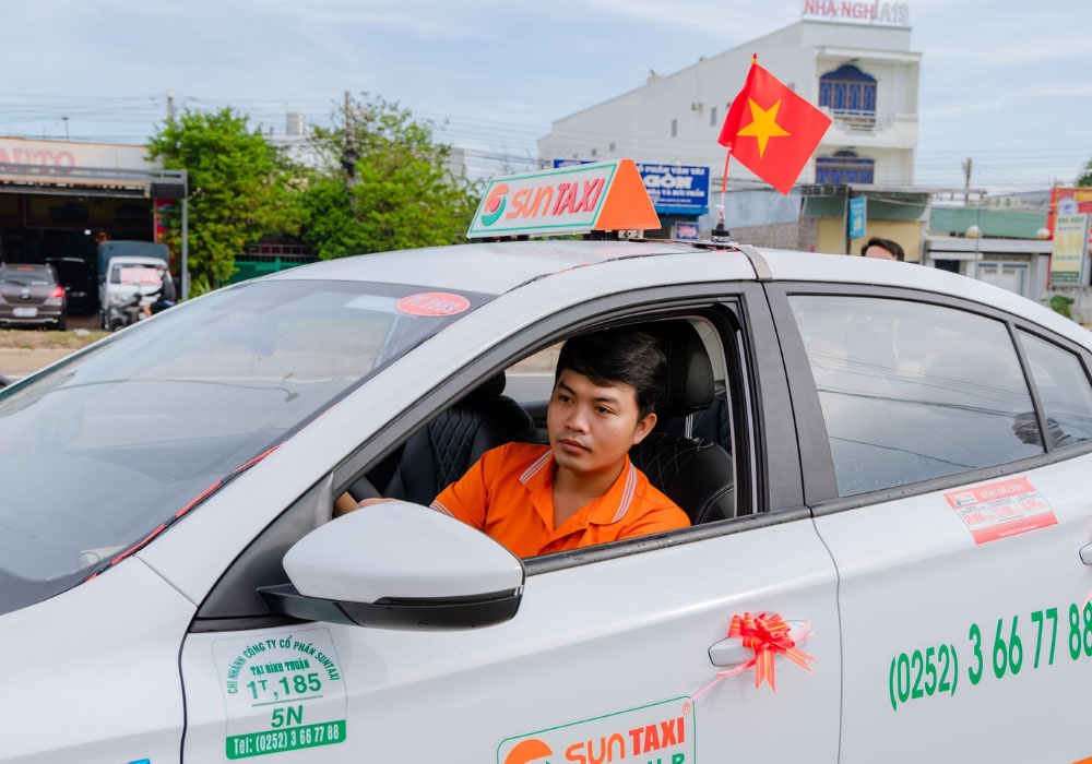 Thương hiệu taxi Bình Thuận nổi bật với logo và đồng phục taxi màu da cam 