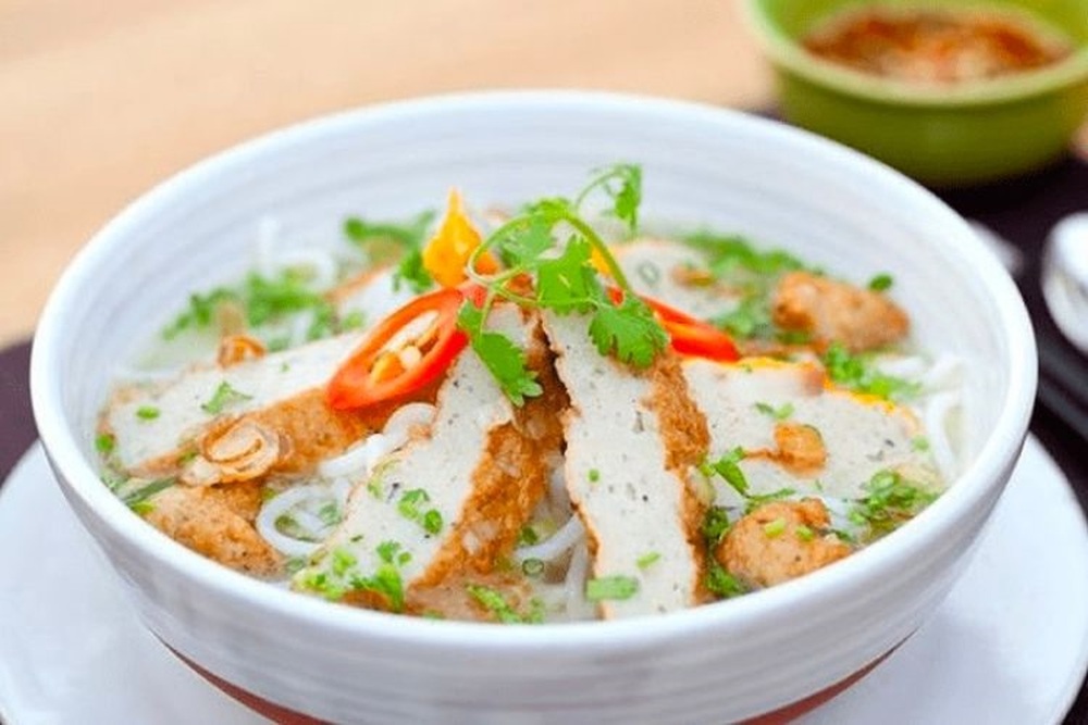 Tô bánh canh chả cá Quy Nhơn nghi ngút khói, với nước dùng trong veo, chả cá vàng ươm, hành lá xanh mướt (Ảnh: Sưu tầm internet)